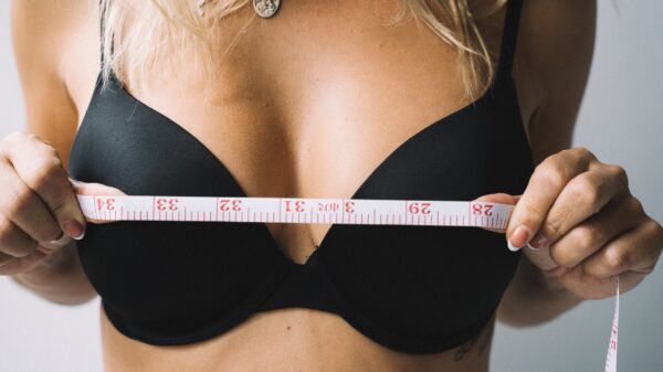 Photo of a Woman Holding a Tape Measure Near Her Chest